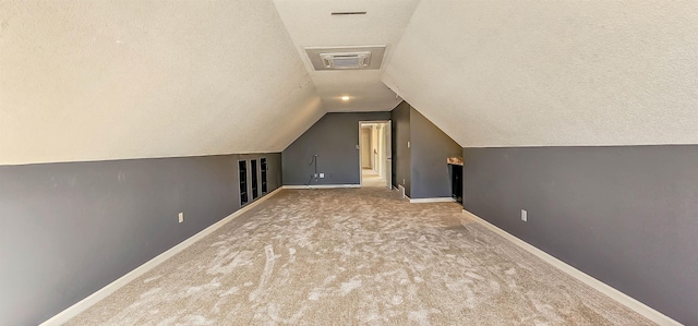 bonus room with vaulted ceiling, carpet flooring, and a textured ceiling