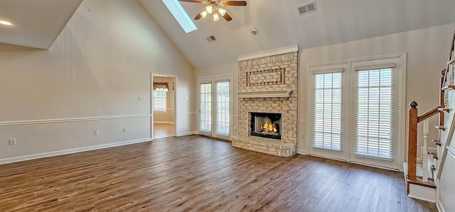 unfurnished living room featuring hardwood / wood-style flooring, ceiling fan, a healthy amount of sunlight, and high vaulted ceiling