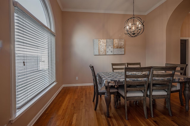 dining area with ornamental molding, wood-type flooring, and a chandelier