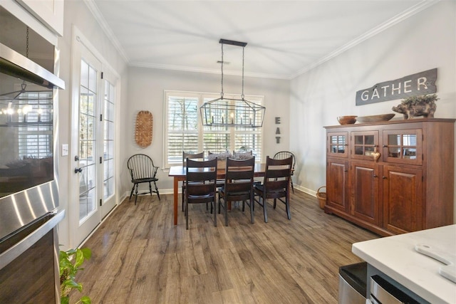 dining space featuring dark hardwood / wood-style flooring, crown molding, and french doors