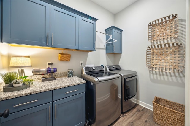 laundry room with separate washer and dryer, dark hardwood / wood-style floors, and cabinets