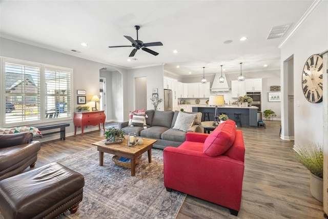 living room featuring ornamental molding, ceiling fan, and dark hardwood / wood-style flooring