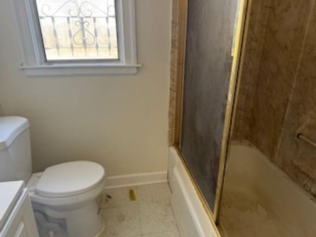 full bathroom featuring vanity, bath / shower combo with glass door, and toilet