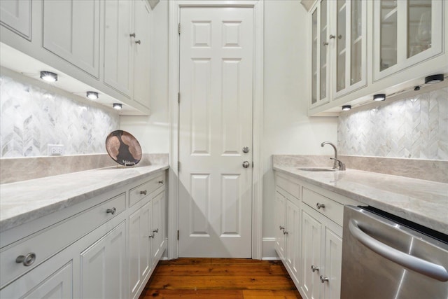 kitchen featuring sink, dishwasher, white cabinetry, light stone counters, and tasteful backsplash