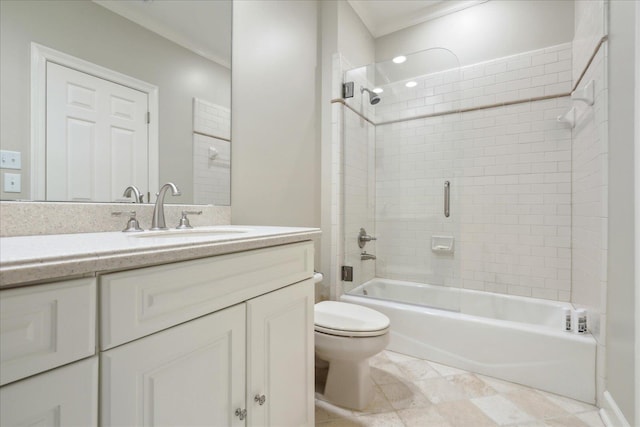 full bathroom featuring crown molding, vanity, toilet, and tiled shower / bath combo