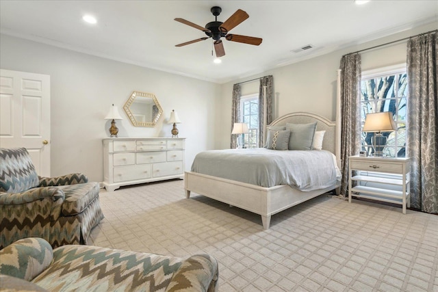 bedroom featuring crown molding, light colored carpet, and ceiling fan