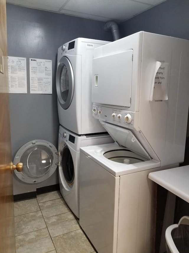 washroom with light tile patterned flooring and stacked washer / drying machine