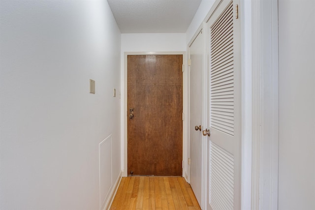 hall featuring hardwood / wood-style flooring and a textured ceiling