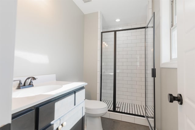 bathroom featuring walk in shower, vanity, toilet, and tile patterned flooring