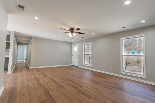 empty room featuring hardwood / wood-style flooring, a wealth of natural light, and ceiling fan