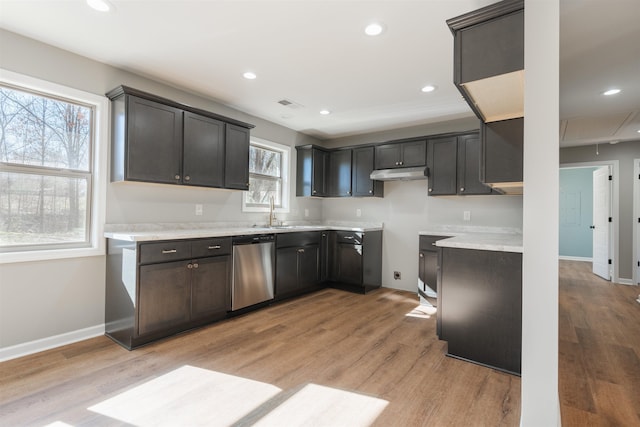 kitchen featuring dark brown cabinetry, sink, stainless steel dishwasher, and light wood-type flooring