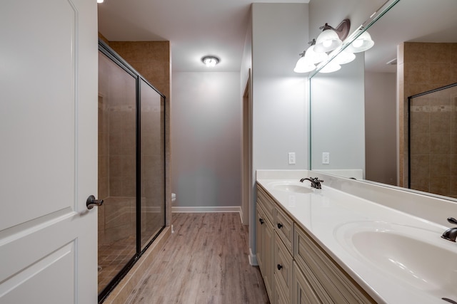 bathroom featuring toilet, vanity, a shower with door, and hardwood / wood-style floors