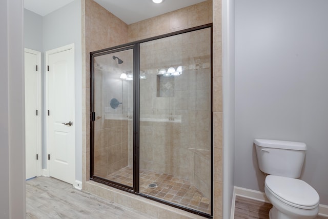 bathroom with wood-type flooring, toilet, and walk in shower