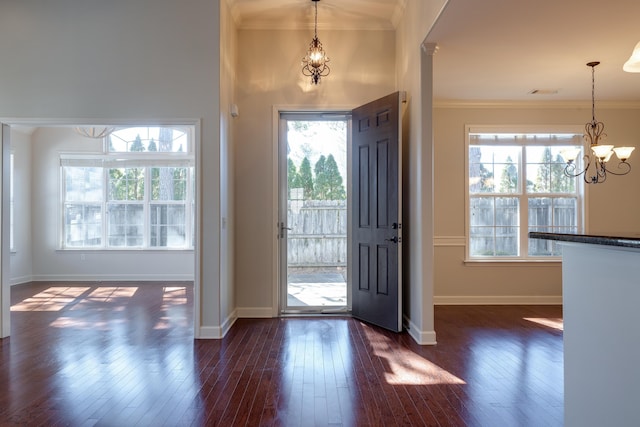 entryway with ornamental molding, dark wood-type flooring, and a wealth of natural light