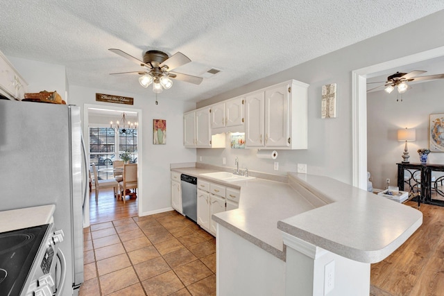 kitchen featuring ceiling fan with notable chandelier, white cabinetry, sink, kitchen peninsula, and stainless steel appliances