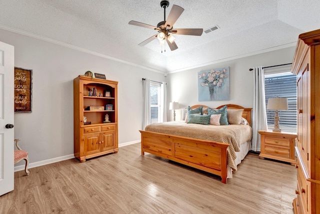 bedroom featuring lofted ceiling, ornamental molding, light hardwood / wood-style floors, and ceiling fan