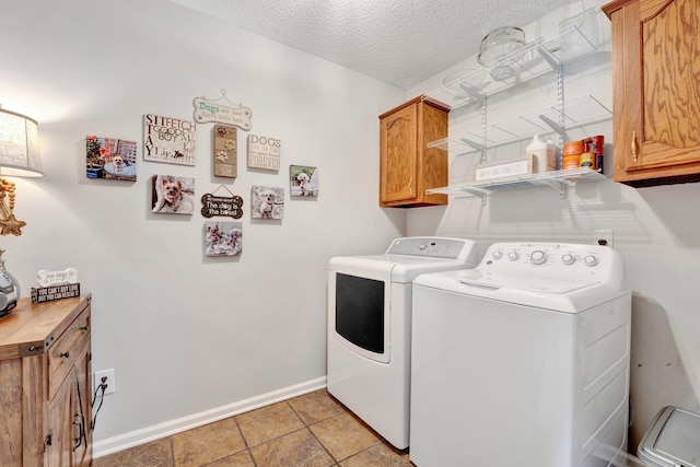 washroom featuring cabinets, independent washer and dryer, and a textured ceiling