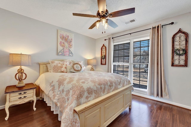 bedroom featuring dark wood-type flooring, a textured ceiling, and ceiling fan