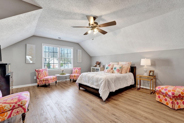 bedroom with ceiling fan, vaulted ceiling, and light hardwood / wood-style flooring