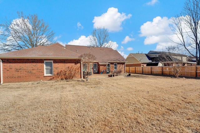 back of house featuring a patio area and a lawn