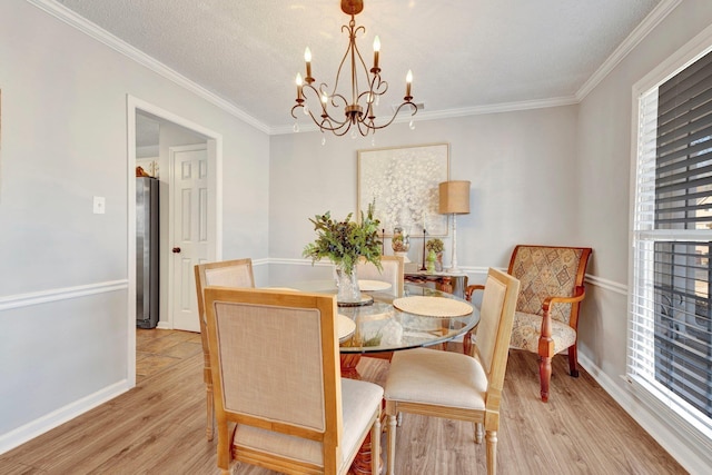 dining room with crown molding, light hardwood / wood-style floors, a chandelier, and a textured ceiling