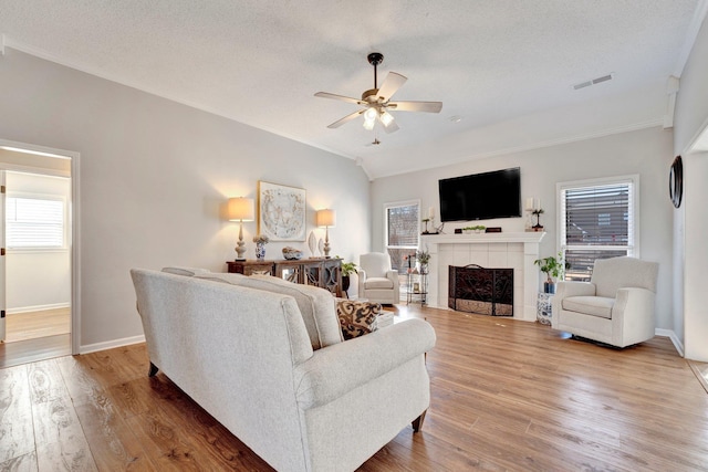 living room featuring a healthy amount of sunlight, ceiling fan, hardwood / wood-style flooring, and a textured ceiling