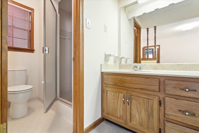 bathroom featuring tile patterned flooring, vanity, a shower with shower door, and toilet