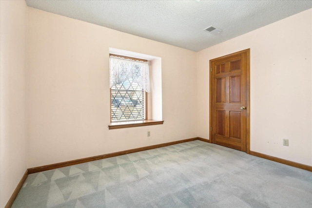 carpeted empty room with a textured ceiling