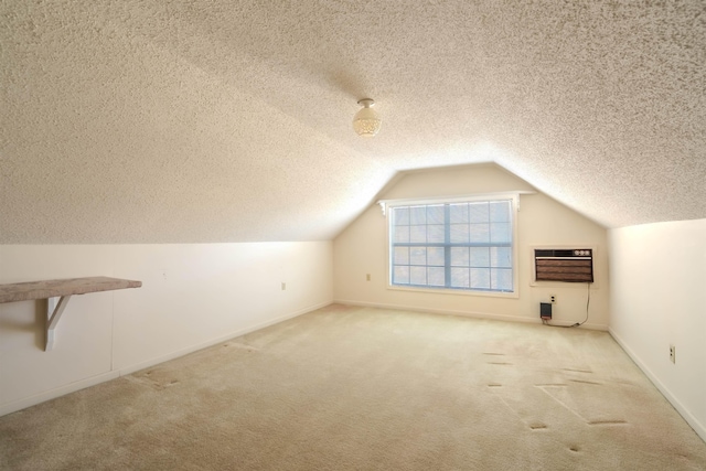 bonus room with lofted ceiling, a wall unit AC, light colored carpet, and a textured ceiling