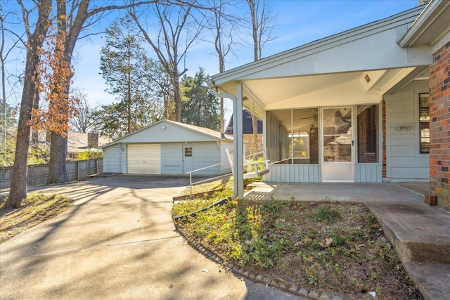 exterior space featuring a garage, an outdoor structure, and a sunroom