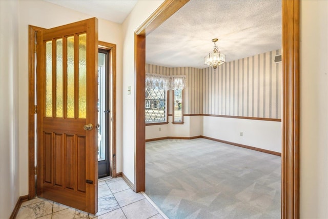 entryway featuring light carpet and a notable chandelier