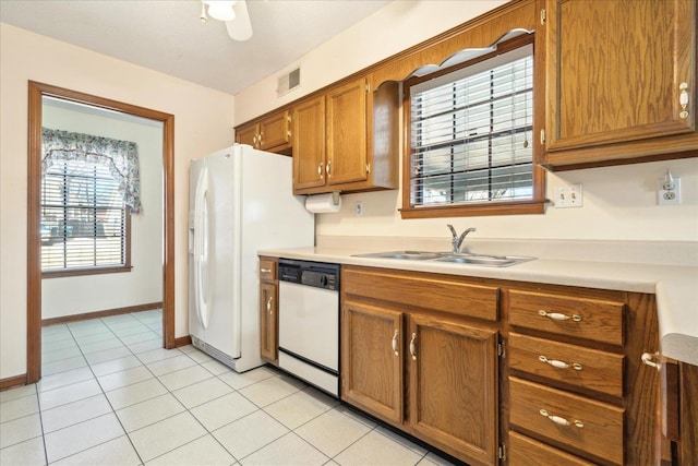 kitchen featuring white appliances, sink, and light tile patterned floors