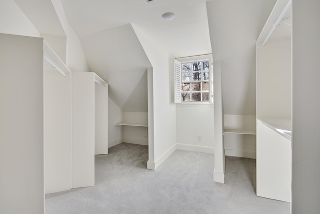 additional living space featuring light colored carpet and vaulted ceiling