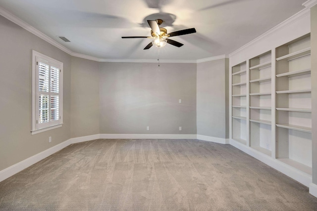 carpeted spare room with crown molding, ceiling fan, and built in features