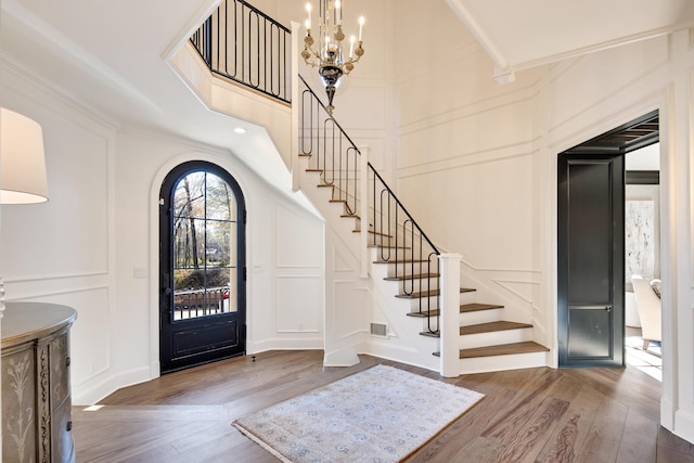 entrance foyer featuring wood-type flooring and a chandelier