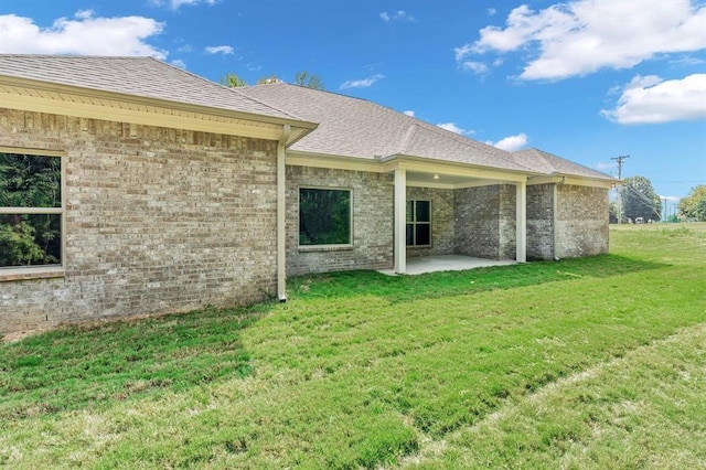 back of property featuring a patio and a lawn