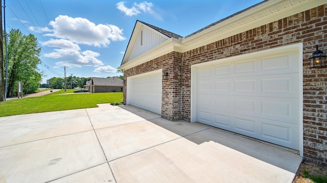 view of side of home with a lawn, driveway, an attached garage, and brick siding