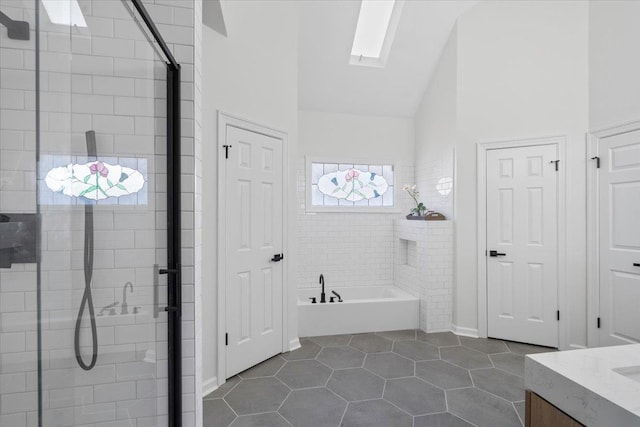 bathroom featuring lofted ceiling with skylight, vanity, tile patterned floors, and plus walk in shower