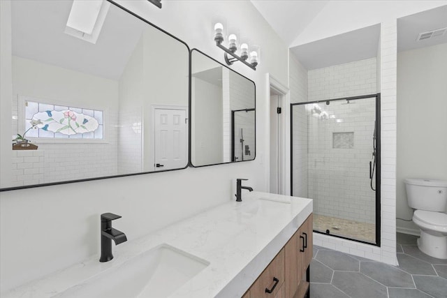 bathroom featuring toilet, lofted ceiling with skylight, an enclosed shower, vanity, and tile patterned flooring