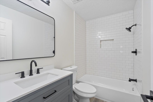 full bathroom with tiled shower / bath combo, vanity, a textured ceiling, and toilet