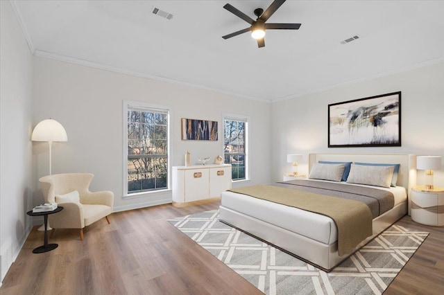 bedroom with hardwood / wood-style flooring, ceiling fan, and ornamental molding