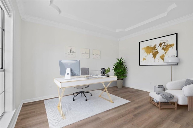 office space with hardwood / wood-style flooring, ornamental molding, and a tray ceiling