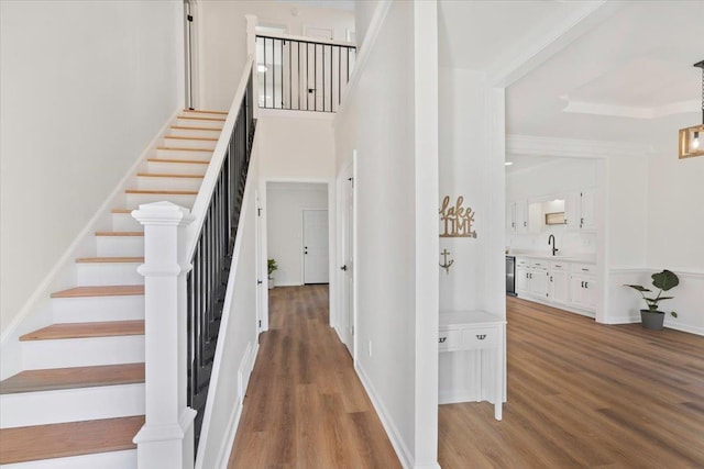 stairway with sink and wood-type flooring