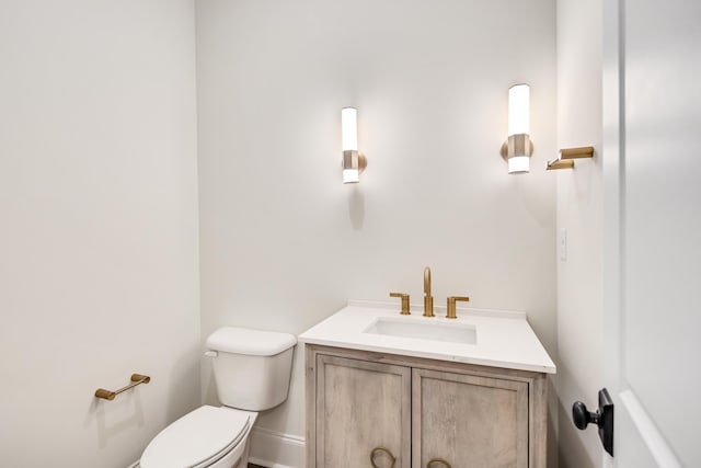 bathroom with vanity, toilet, and baseboards