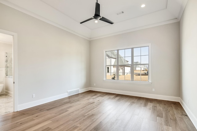 empty room featuring ceiling fan, wood finished floors, visible vents, and baseboards