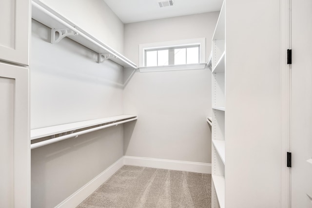 walk in closet with visible vents and light colored carpet