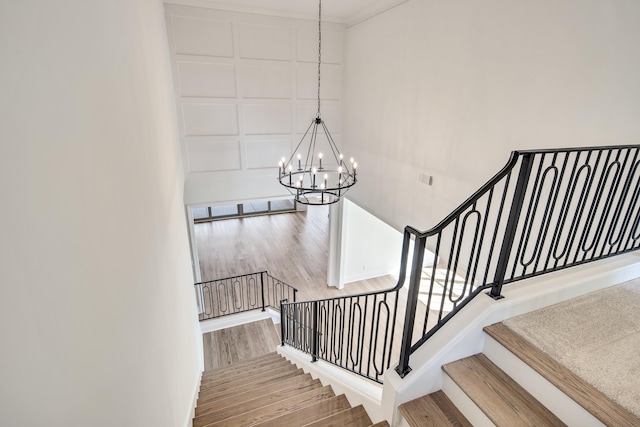 staircase featuring a chandelier, wood finished floors, and visible vents