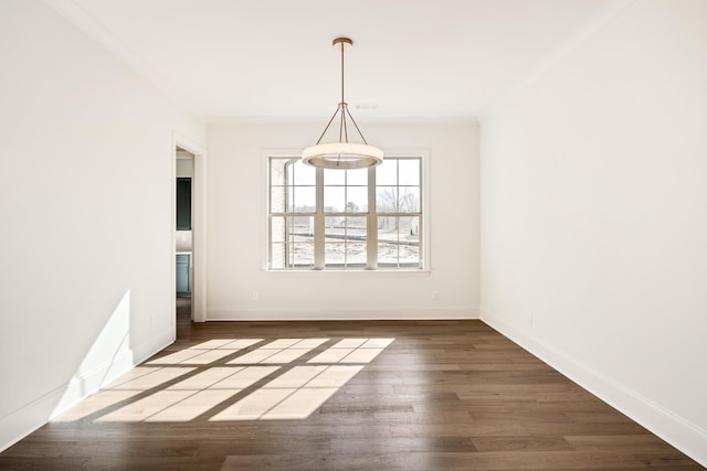 unfurnished dining area featuring crown molding, wood finished floors, and baseboards