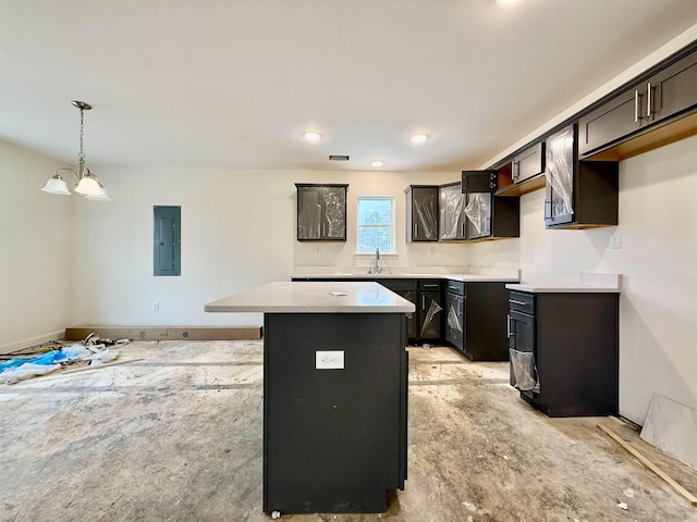 kitchen with electric panel, a center island, light countertops, pendant lighting, and a sink