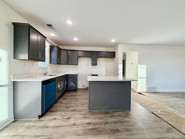 kitchen with a kitchen island, visible vents, light countertops, and a sink